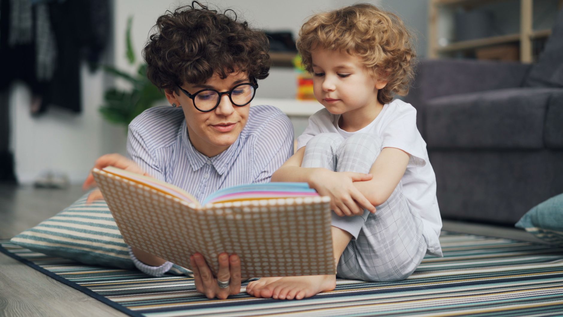 Caregiver and child reading together at home